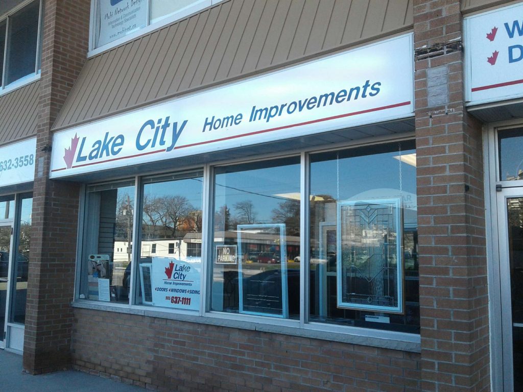 photo of the sign at Lake City Home Improvement store that is white, blue and red with a half a red maple leaf