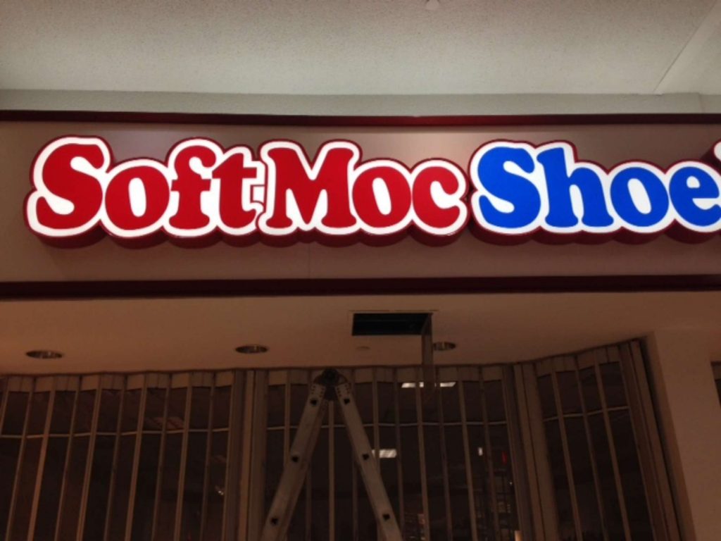 a photo of the softmoc shoe store sign that has red and blue lettering