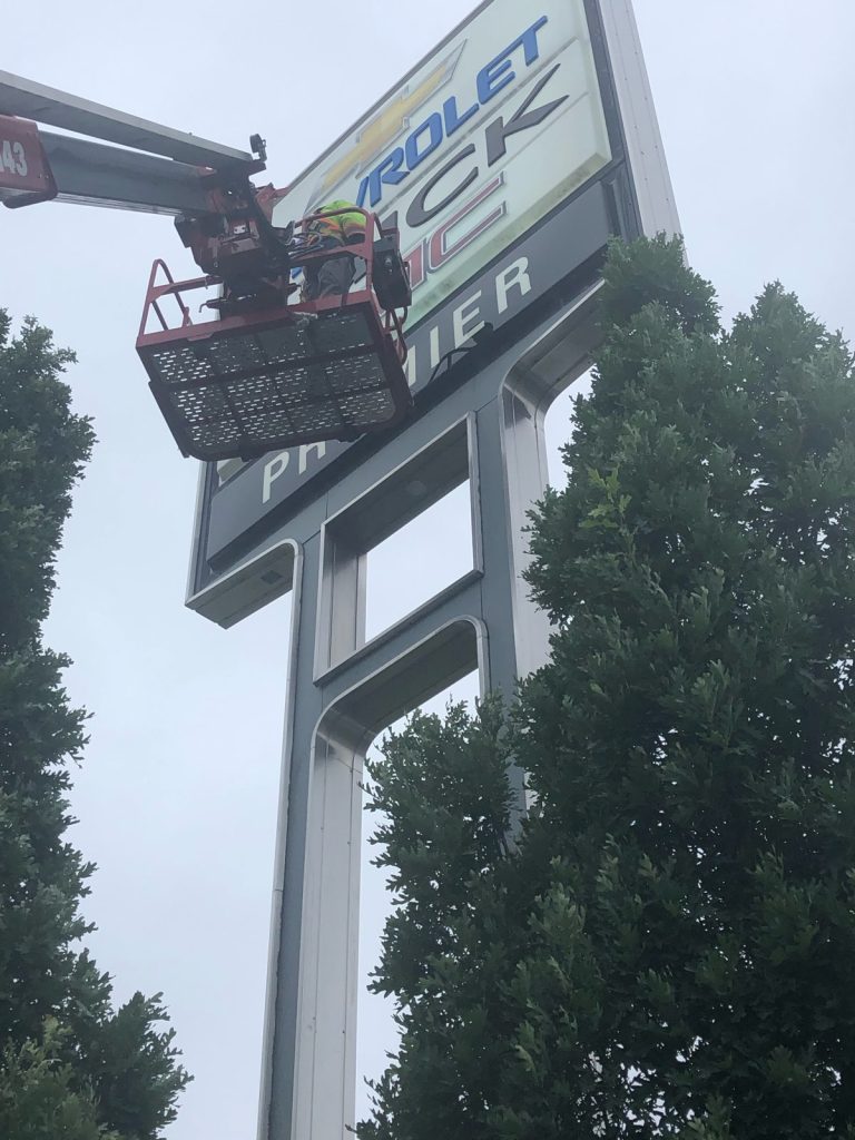 Yesco bucket ladder servicing a 30 foot sign for Premier Chevrolet Buick dealership