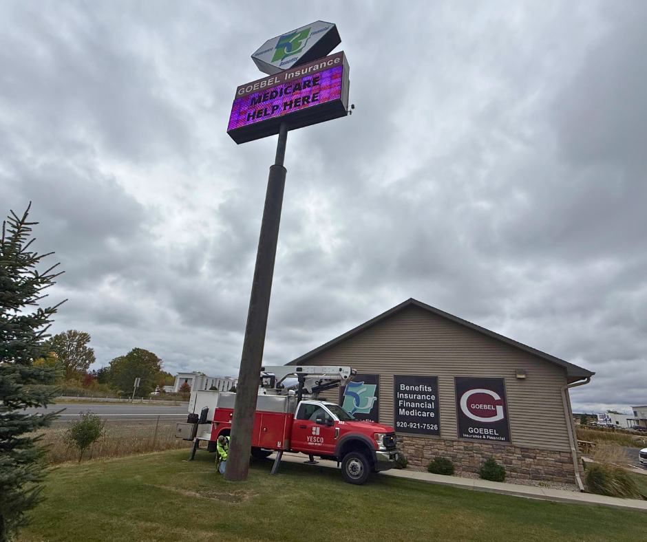 YESCO employee repairing sign/pole