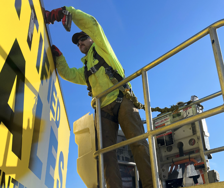 yesco employee fixing a sign