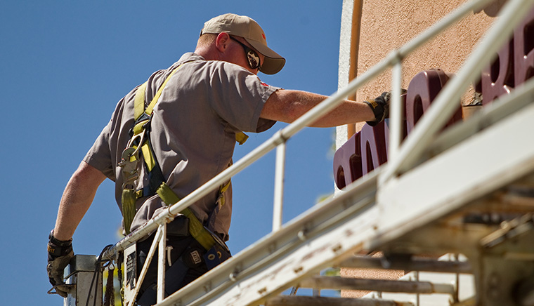 Worker is reparing the Sign board