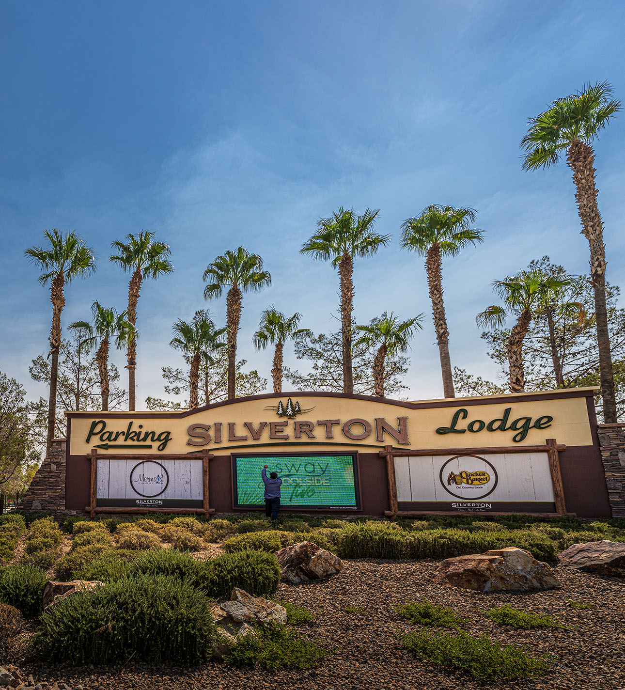 A person stands in front of the Silverton Lodge sign