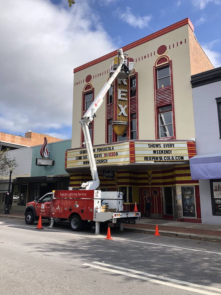 YESCO technicians service the historic yellow neon Rex Theater marquee sign in downtown Pensacola, Florida.