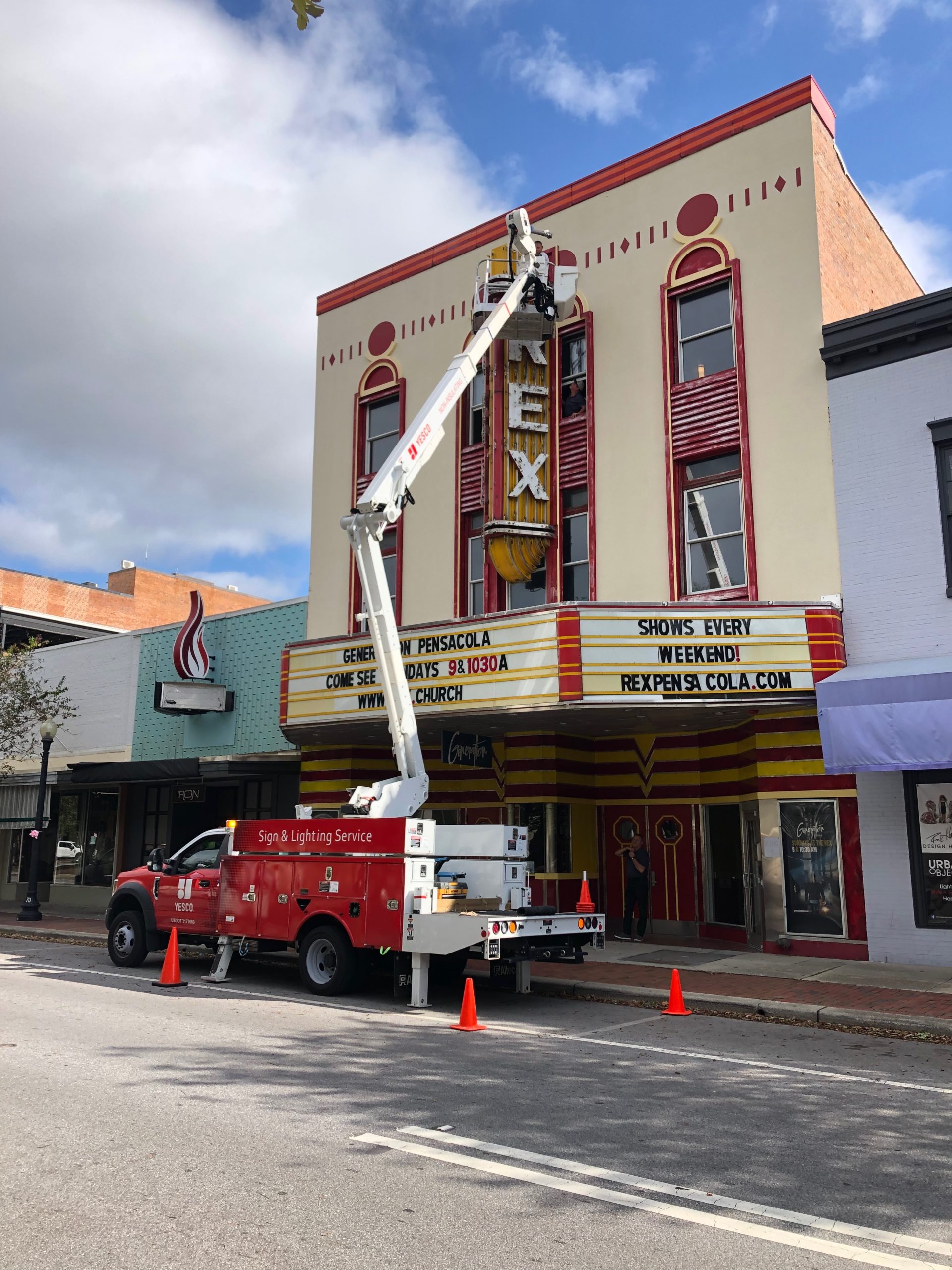 YESCO technicians service the historic yellow neon Rex Theater marquee sign in downtown Pensacola, Florida.