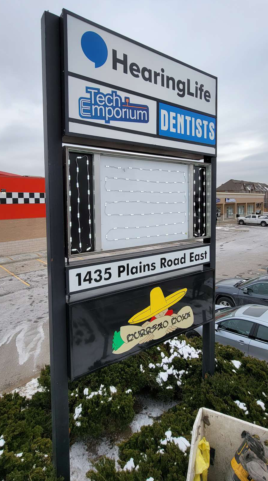 a pylon retrofit of a blue, white and black sign for Hearing Life, Tech Emporium