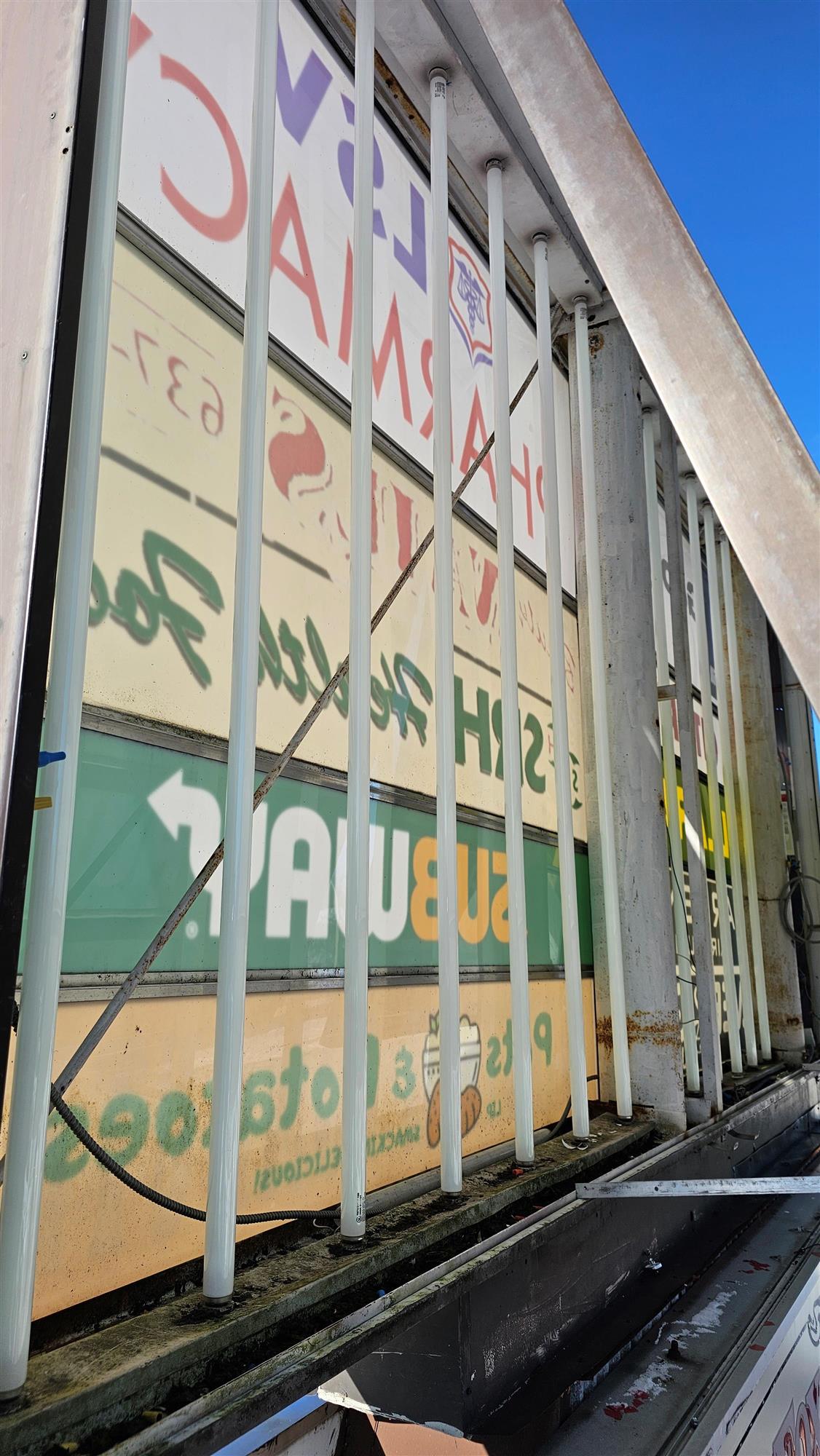 The inside of a pylon sign that shows the lights and backs of signs