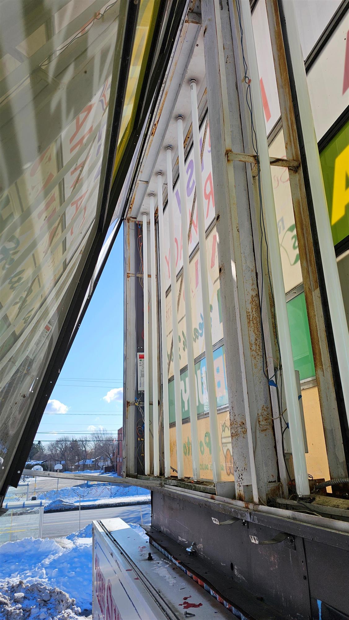 The inside of a pylon sign that shows the lights and backs of signs