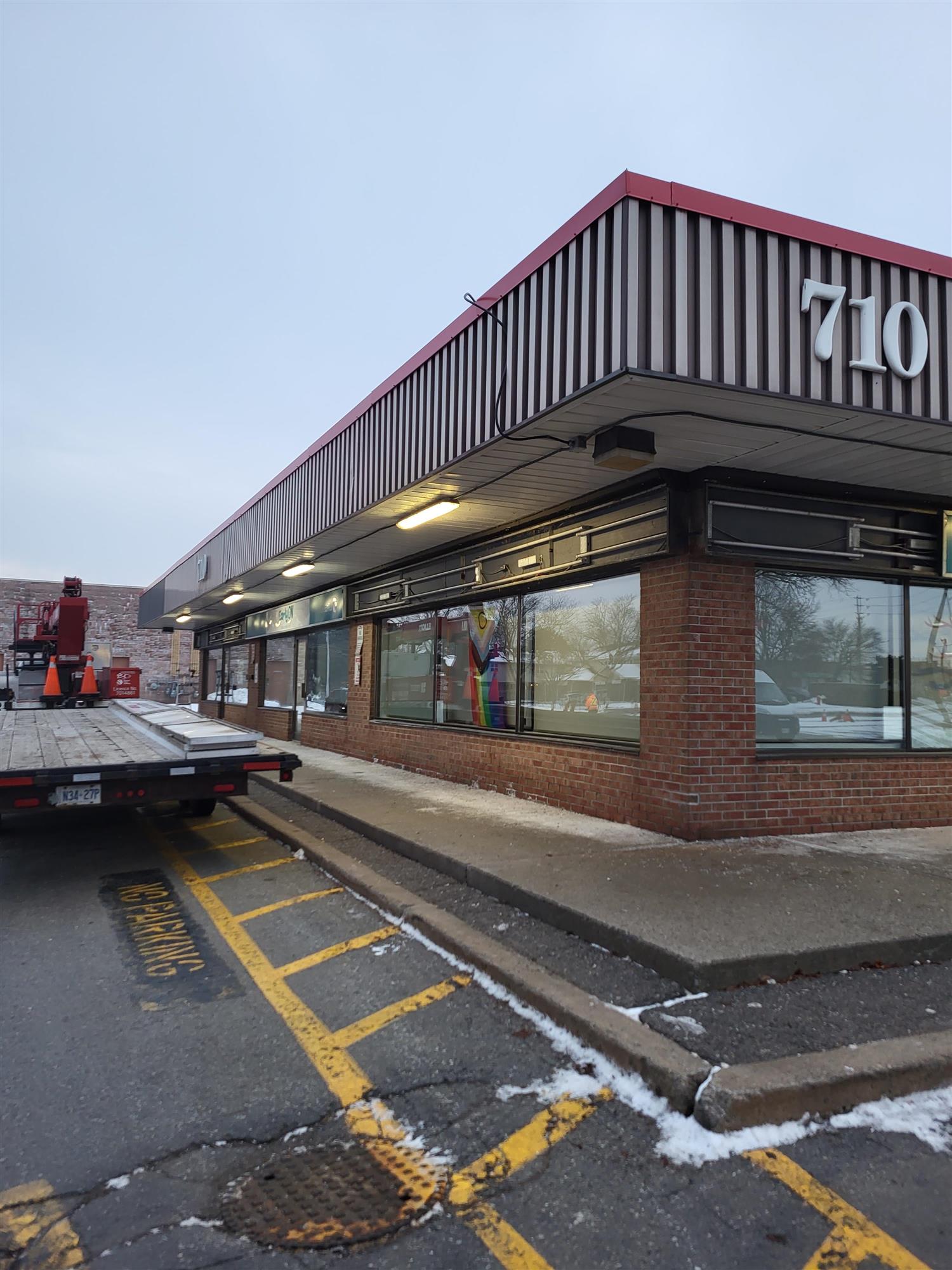 Yesco truck beside brick building preparing for sign installation