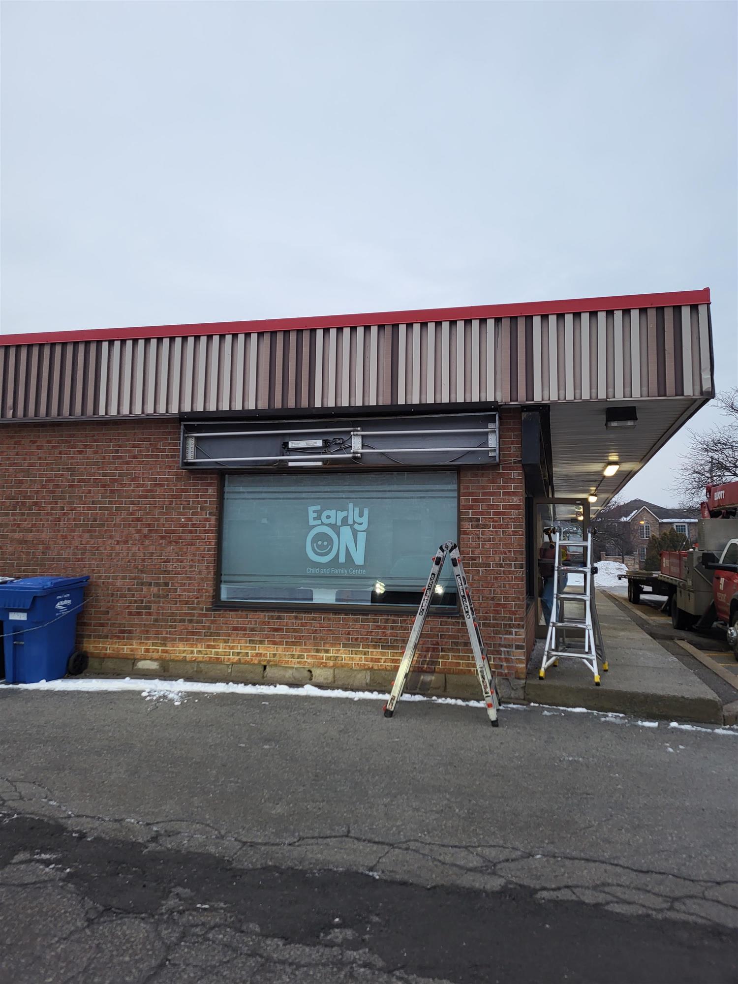 new sign being installed on the side of the building at Early ON Child and Family Centre