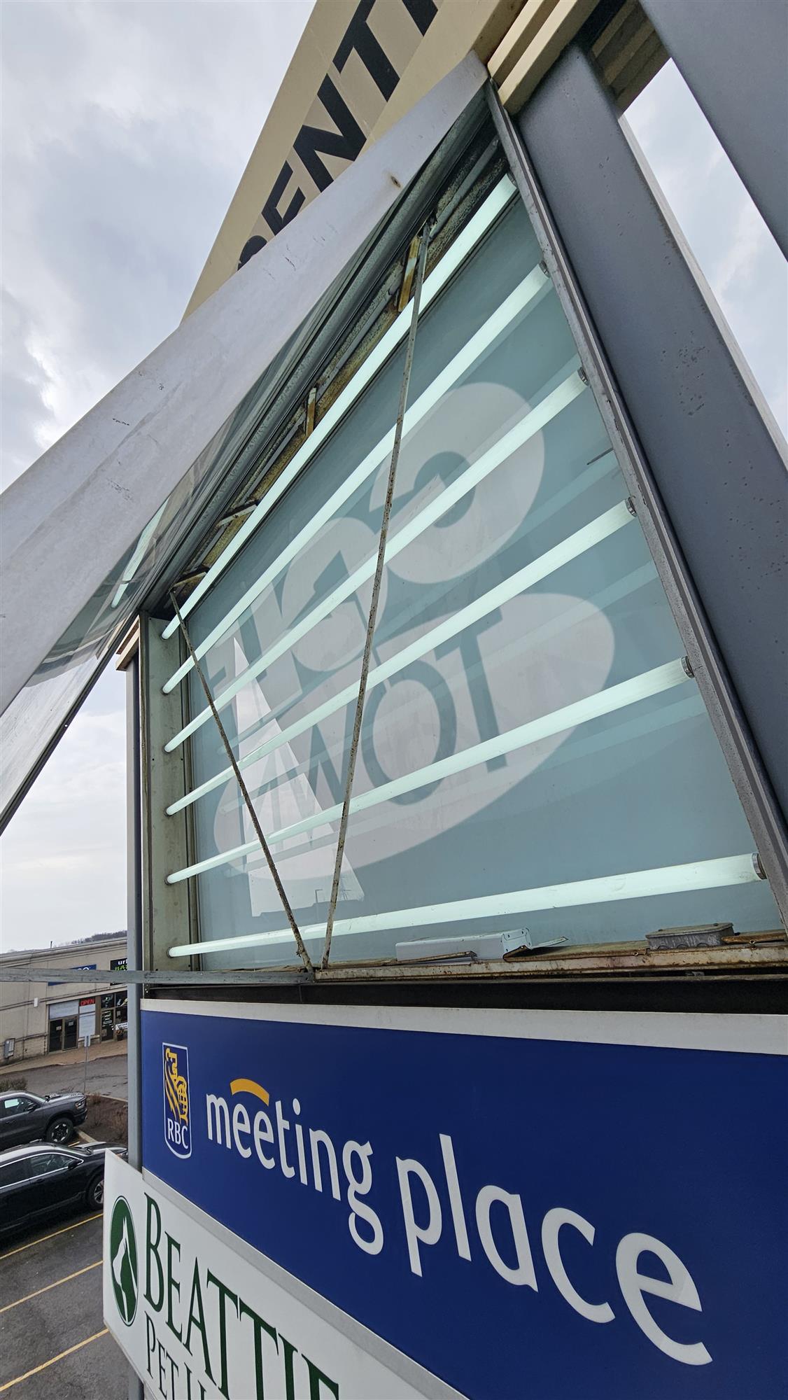 Interior view of a pylon sign showing fluorescent light bulbs requiring replacement