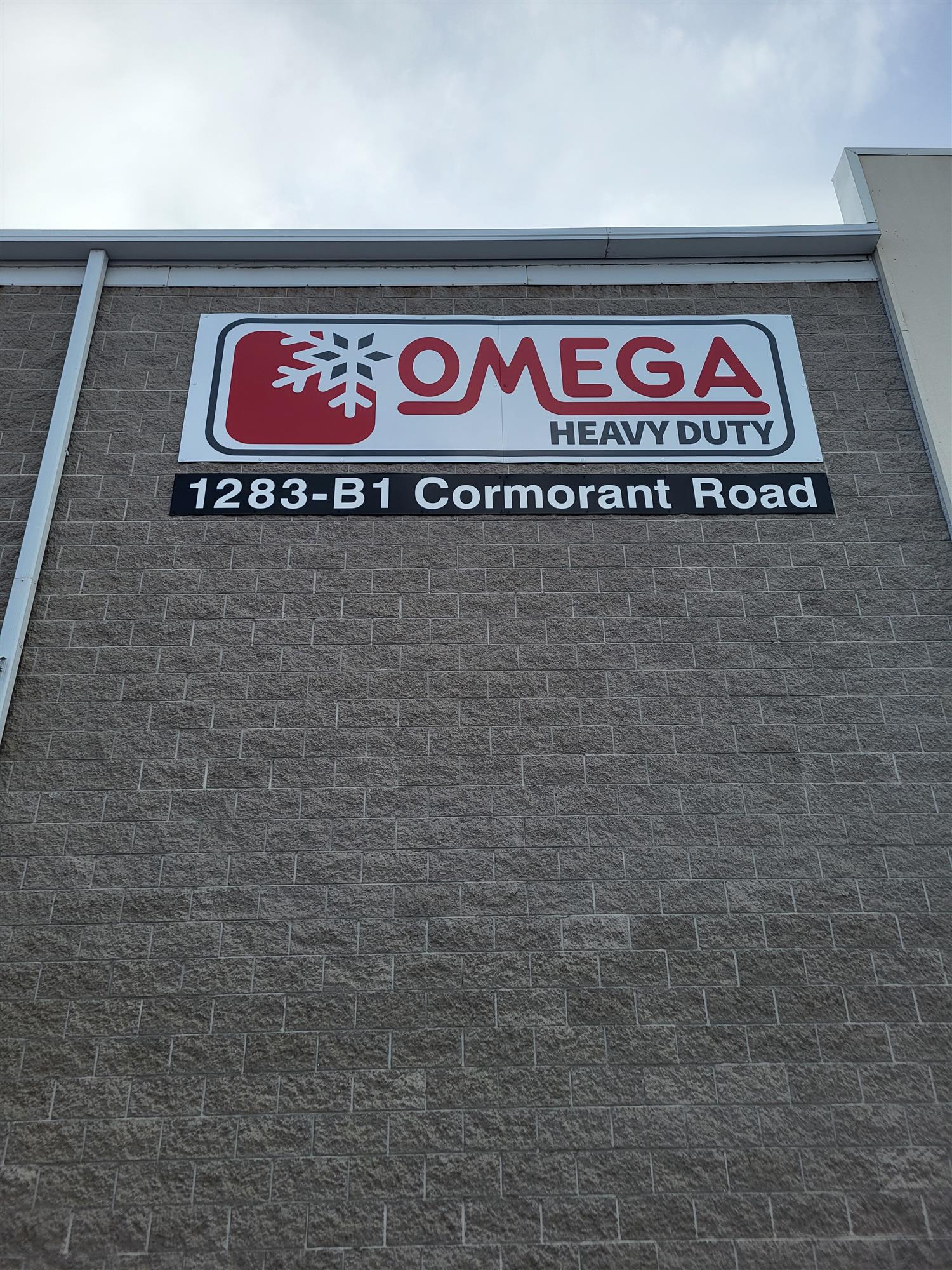 Brick building with red and white Omega sign at the top