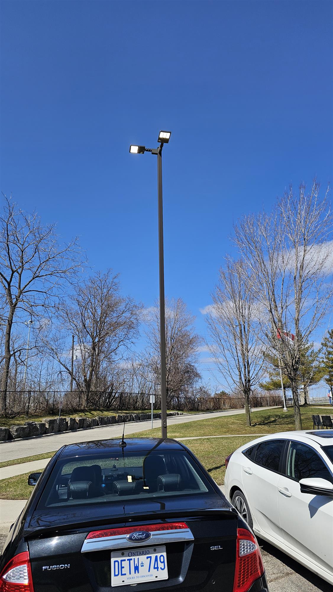 parked cars in lot with tall pole light illuminated