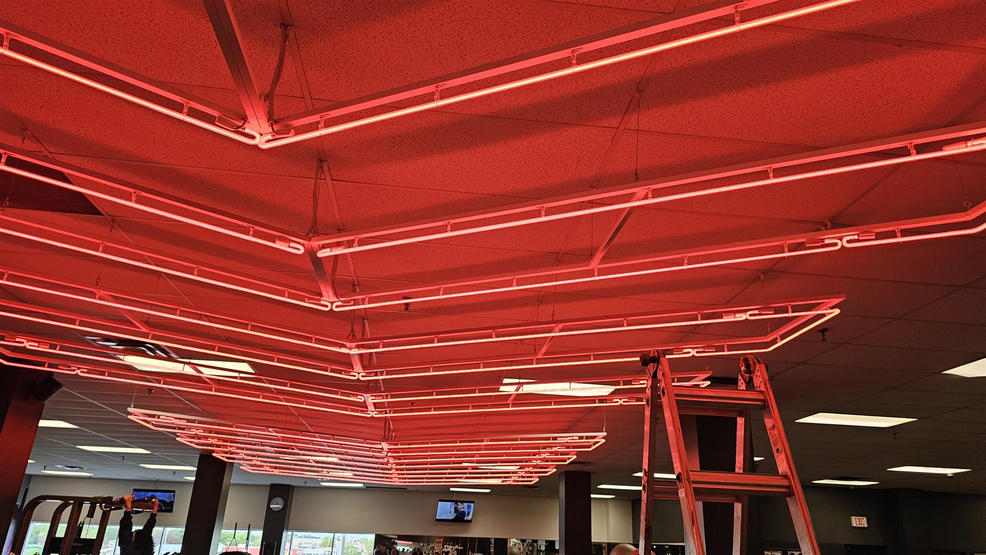 red neon lights on ceiling of Good Life Fitness