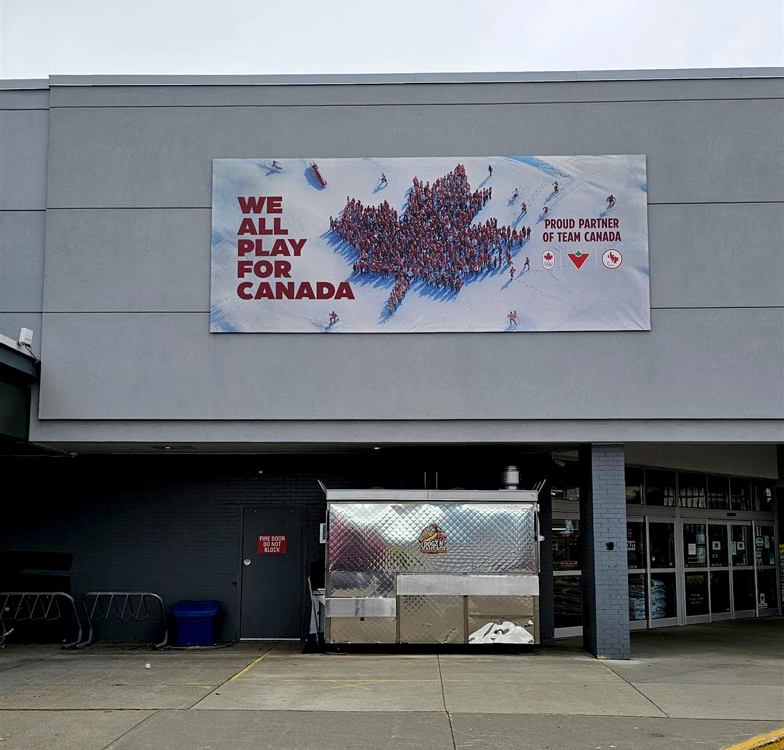 Sign on Canadian Tire building that says We all play for Canada