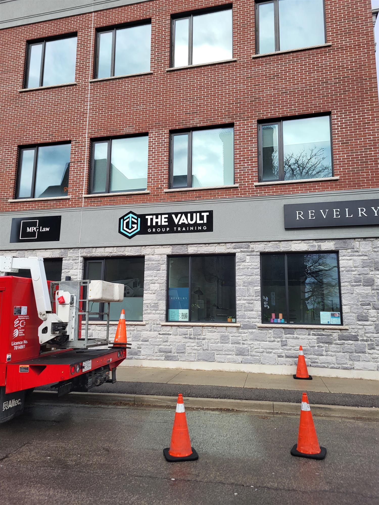 a red and grey brick building with business signs on main level
