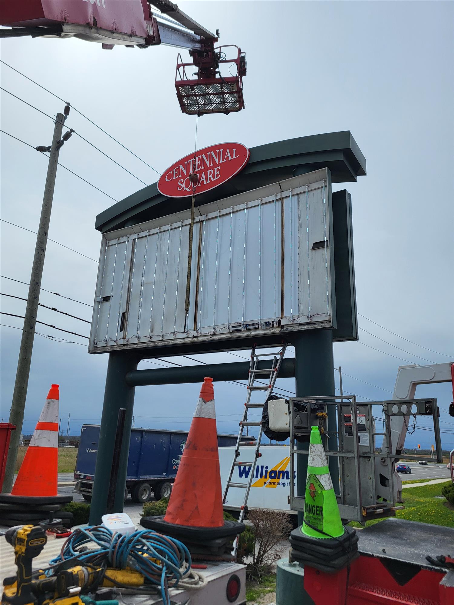 a ladder truck over a large pylon sign Centennial Square plaza