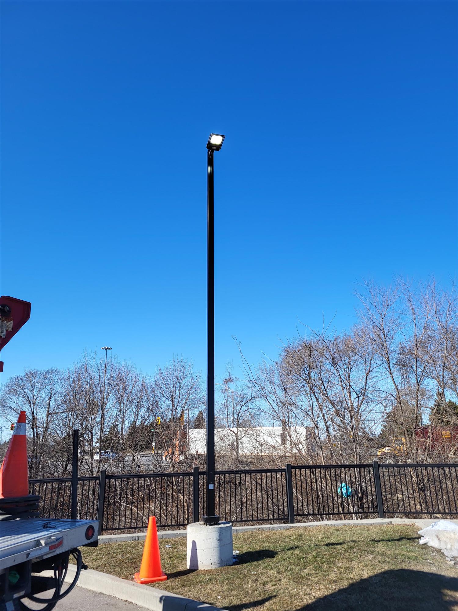 a pole light in a parking lot at the Sandman hotel with very blue sky on winter day