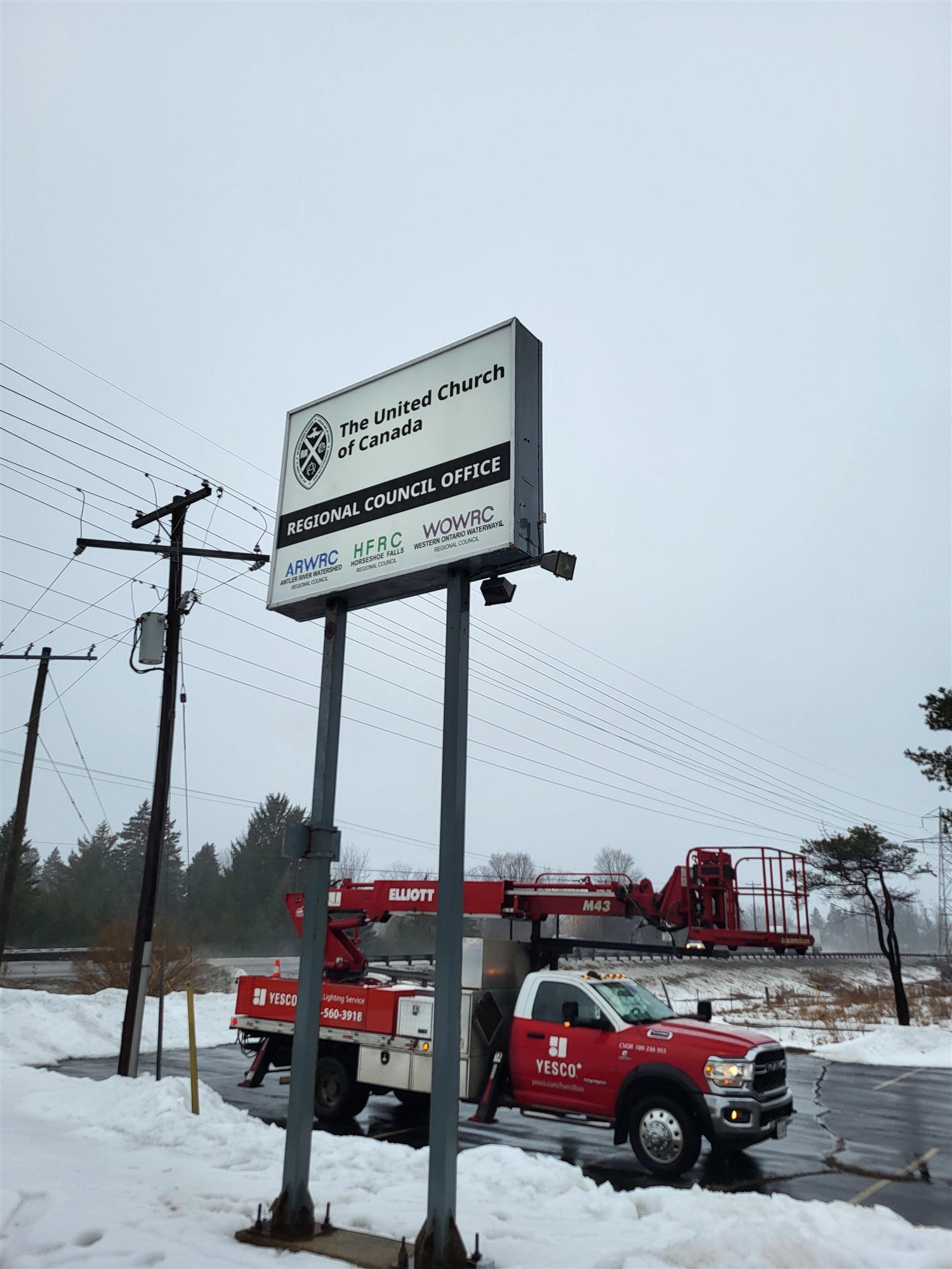 a white and black sign pylon sign for the United Church of Canada Regional council office