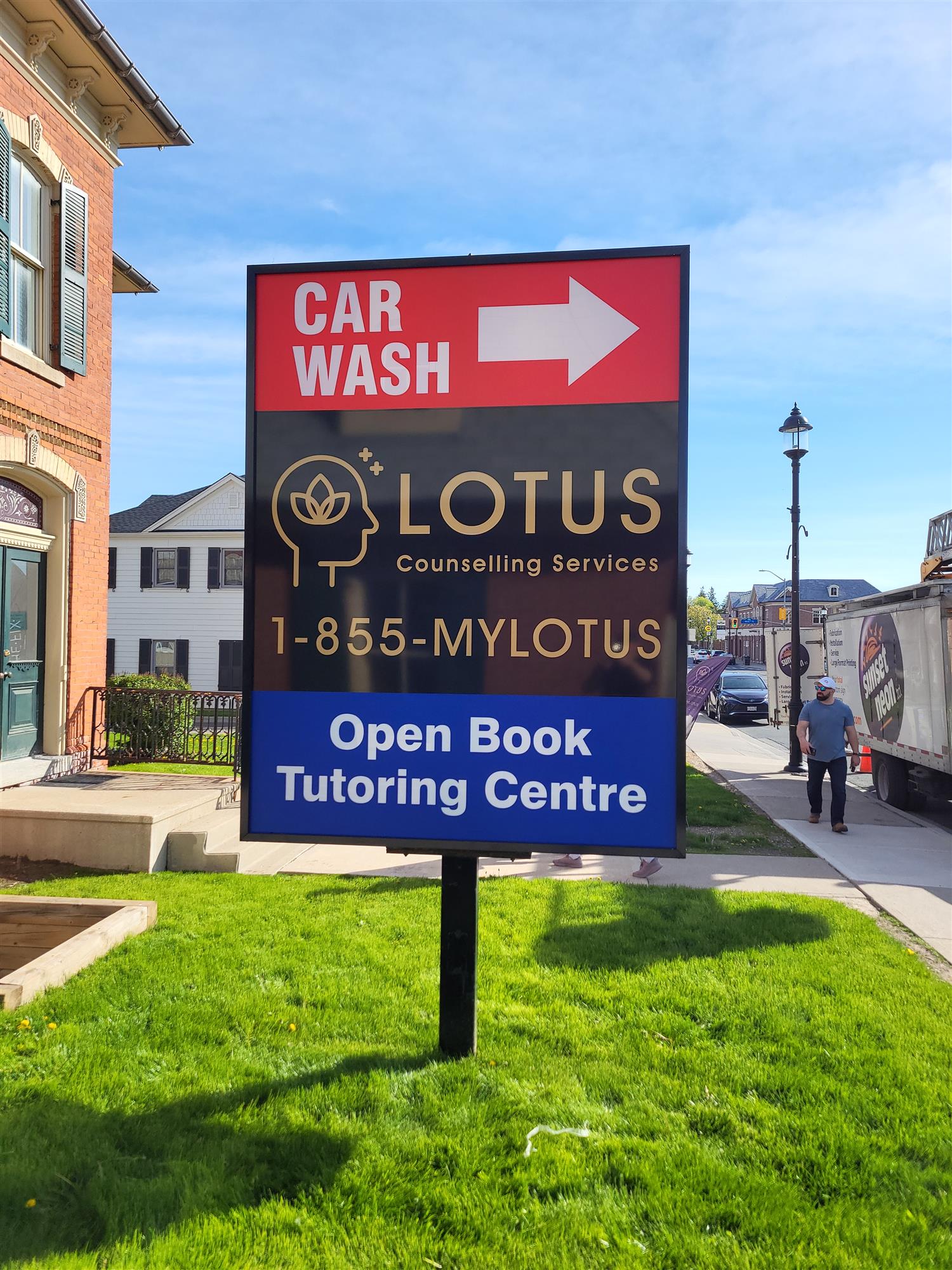 a pylon sign on front lawn highlighting a car wash and other businesses