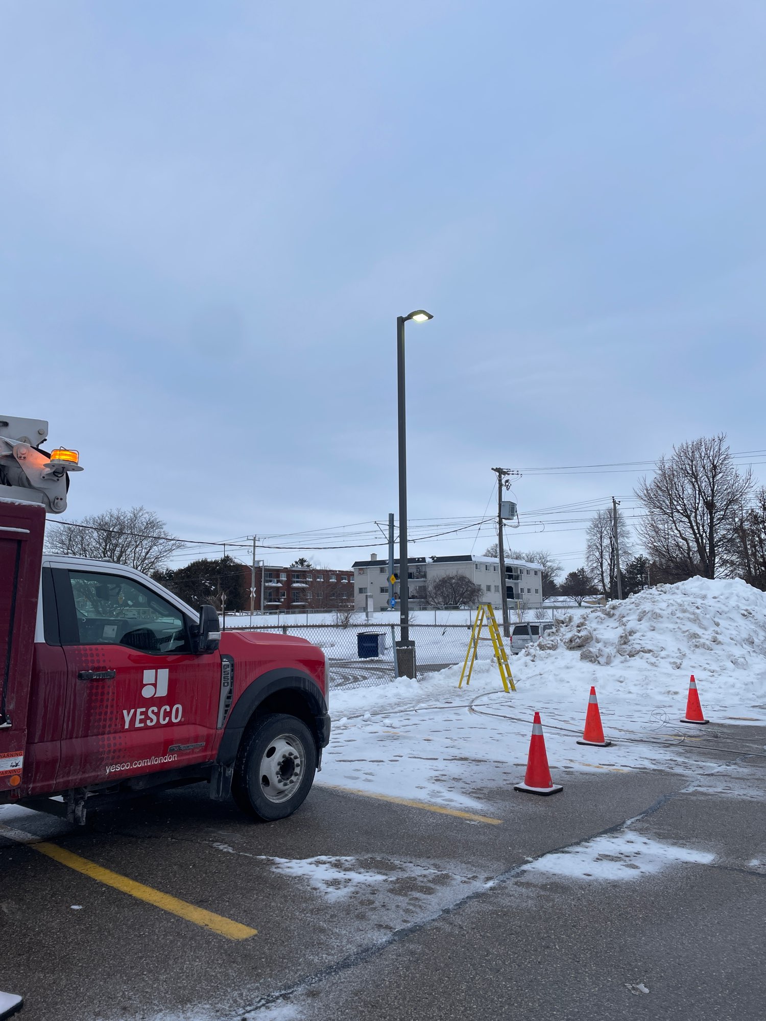 a red Yesco truck beside a parking lot light that required power restoration