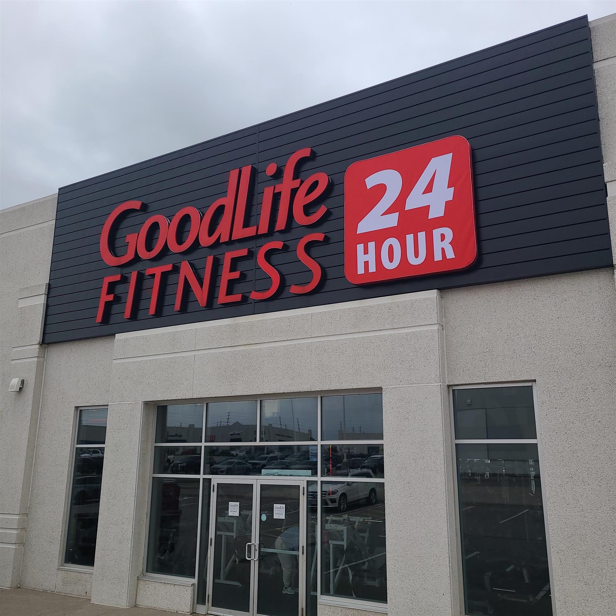 a large red and black and white outdoor sign for GoodLife Fitness 24 hours in London Ontario