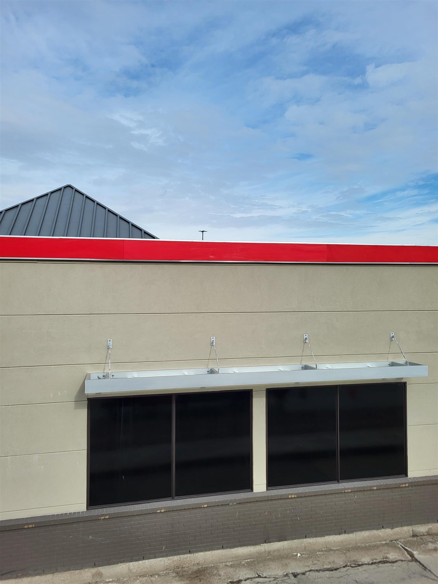 the side of a small building with a red horizontal banner