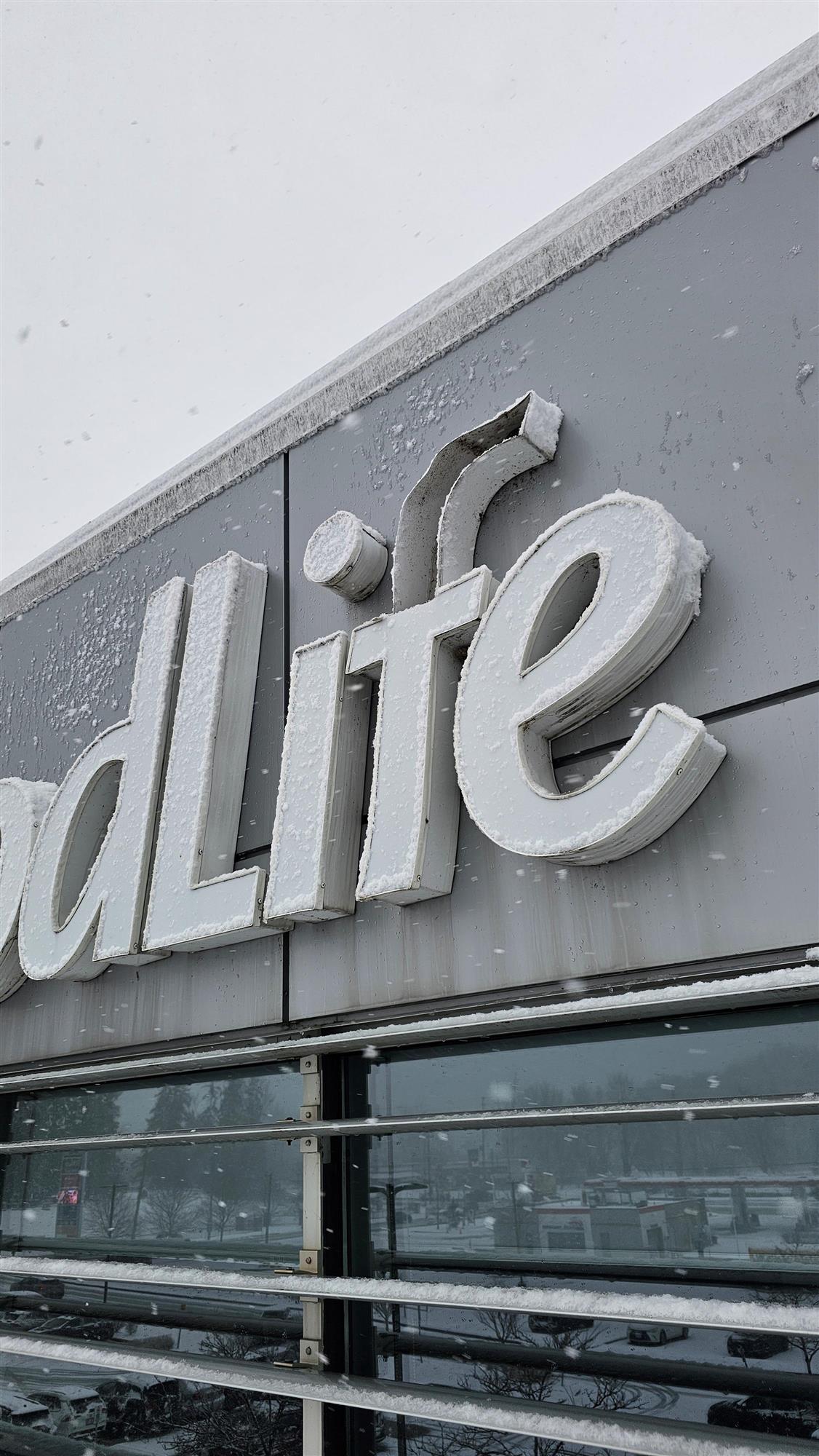 outside on a snowy day showing part of GoodLife sign and the letter F broken