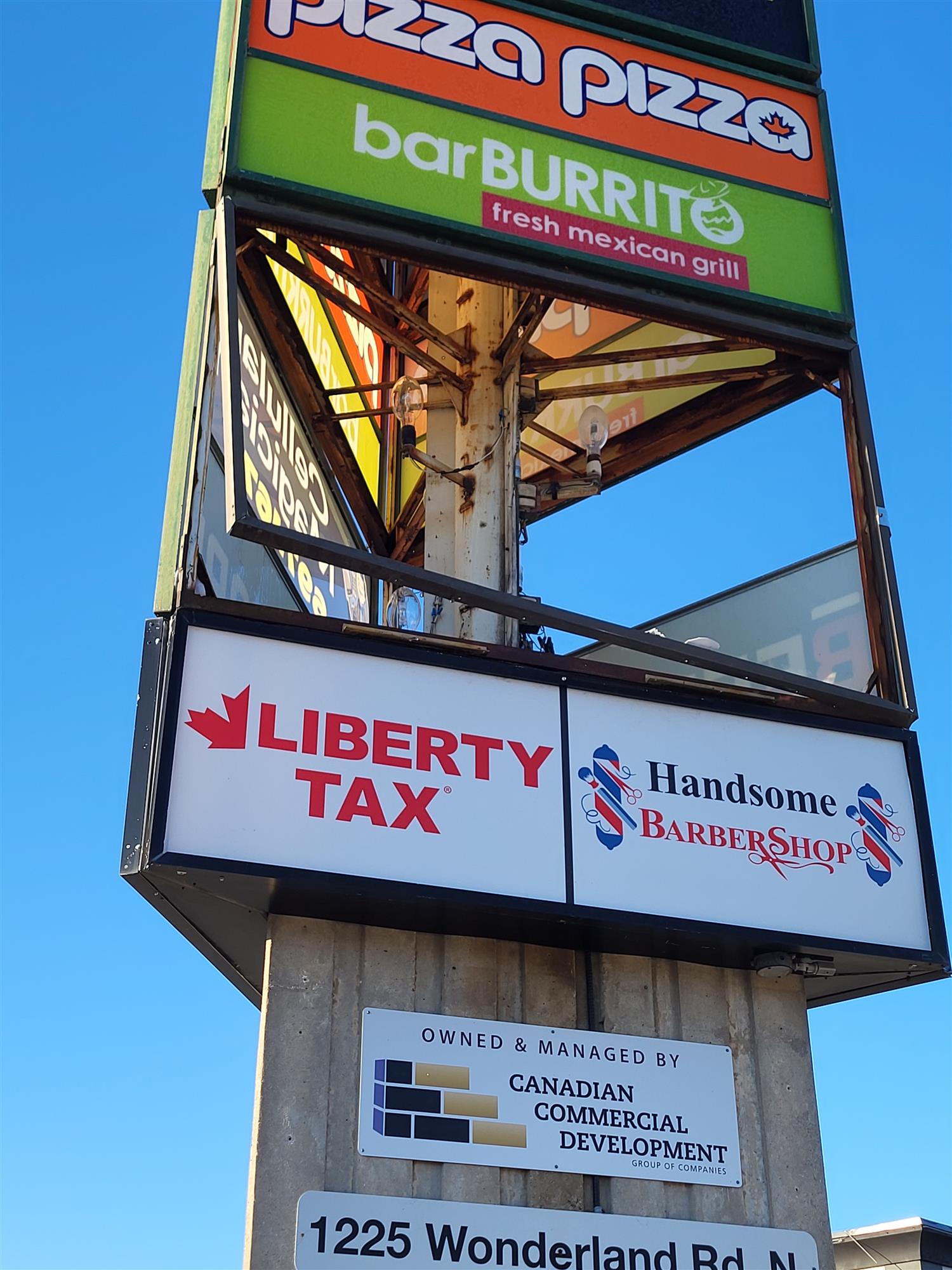 a multi business pylon sign with a section missing