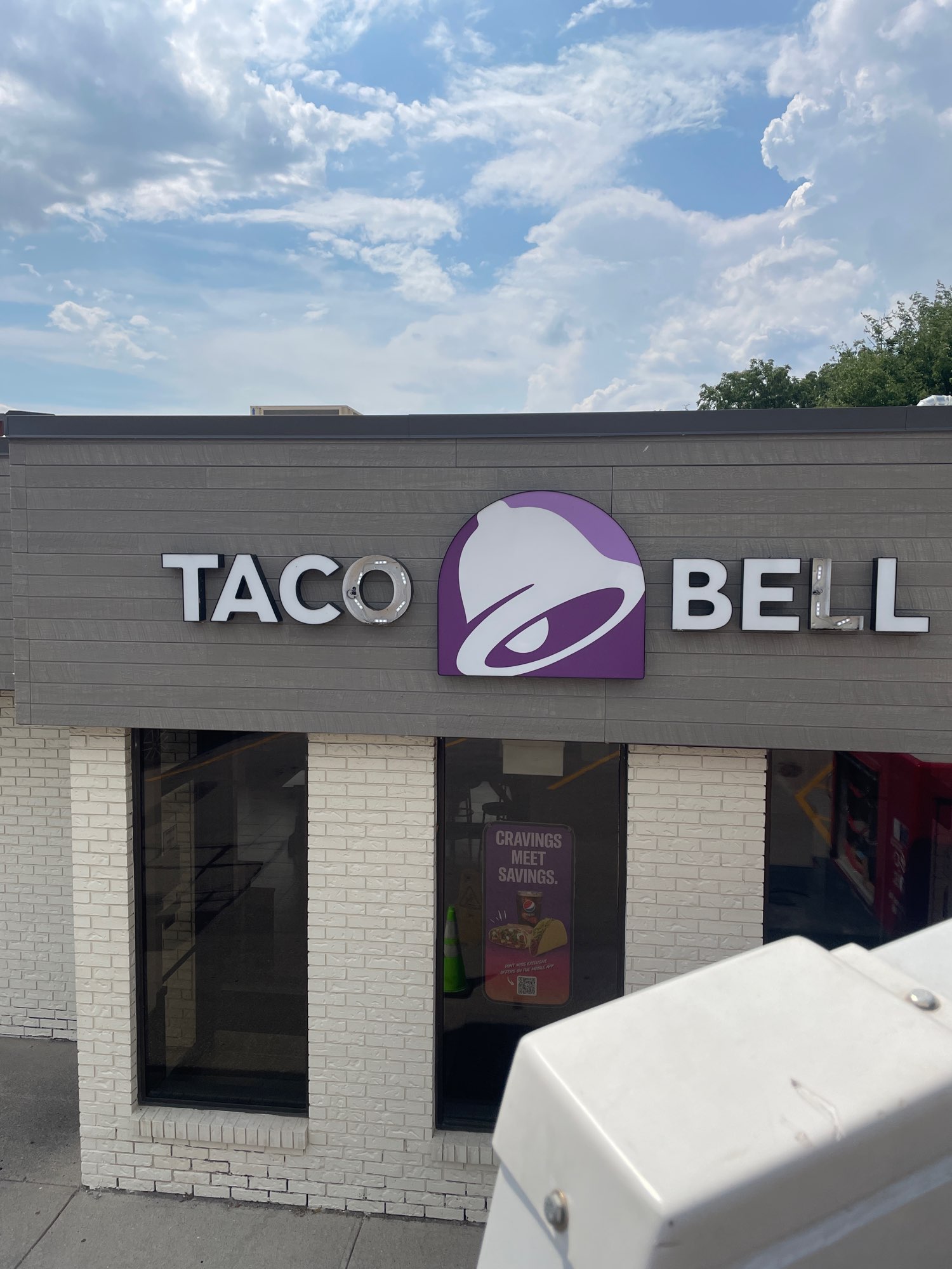 a white and purple Taco Bell store sign showing burnt out lights in Brantford Ontario