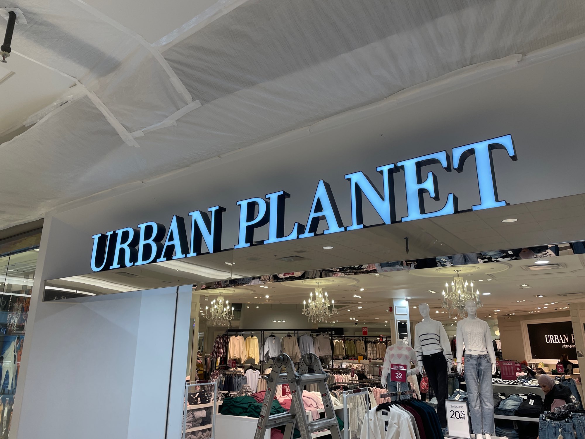 a large blue lettered sign above the Urban Planet store in London Ontario