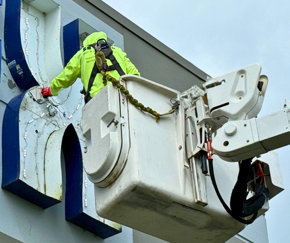 YESCO employee fixing a sign