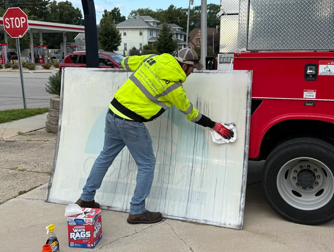 YESCO employee cleaning a sign for a customer