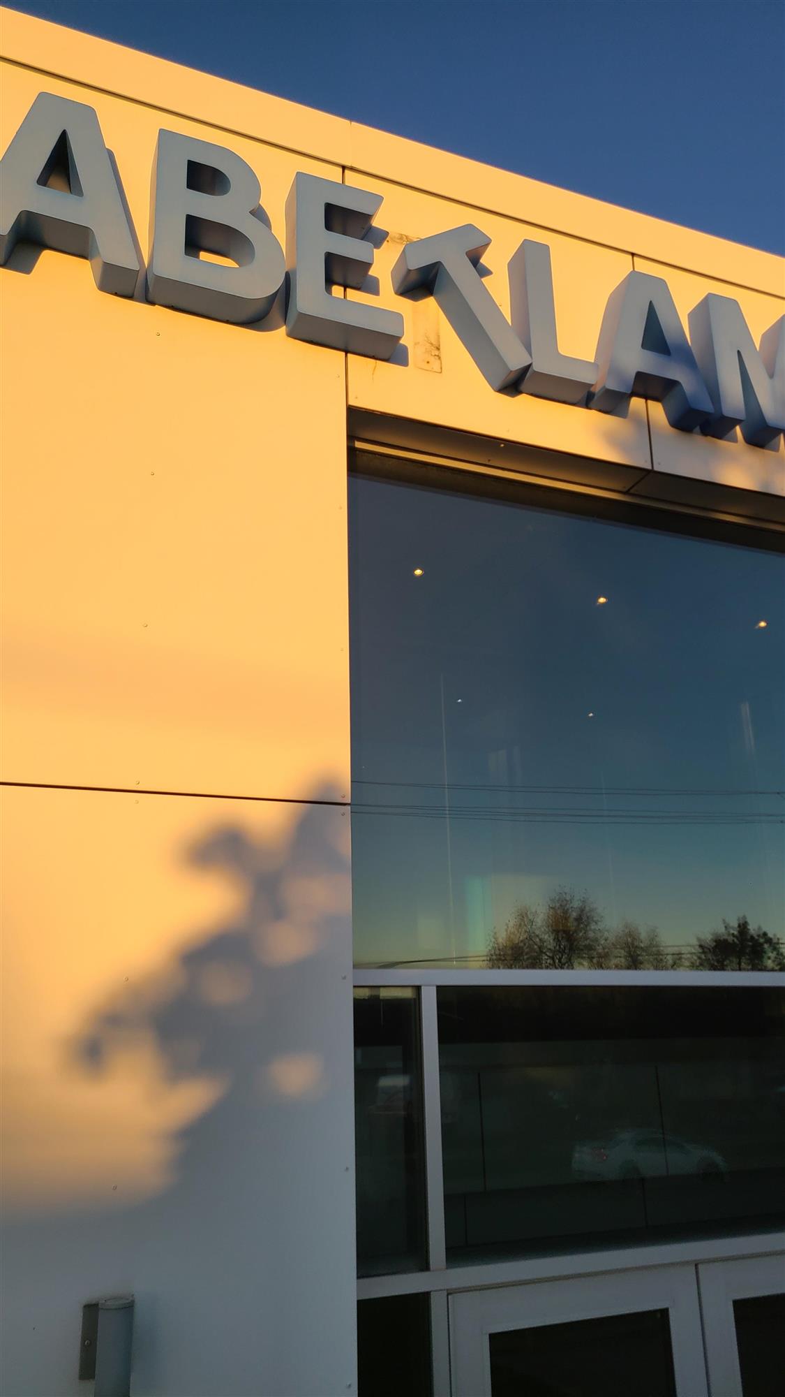 Abet Laminati sign with large blue letters and the letter T askew