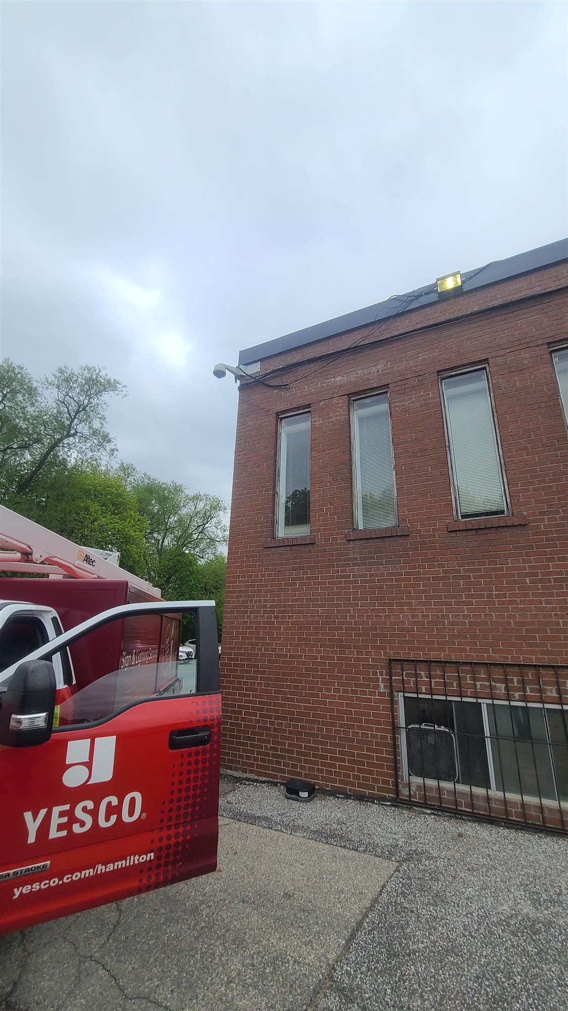a red Yesco truck beside a red brick building