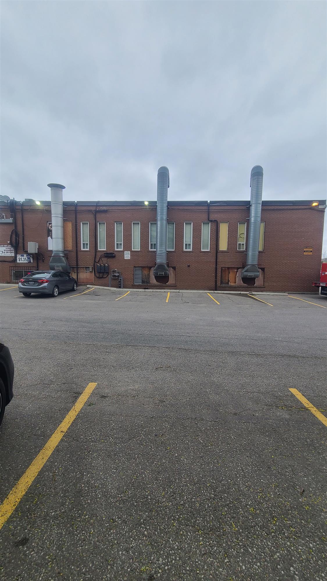 a brick building with 3 silver exhaust stacks running vertically