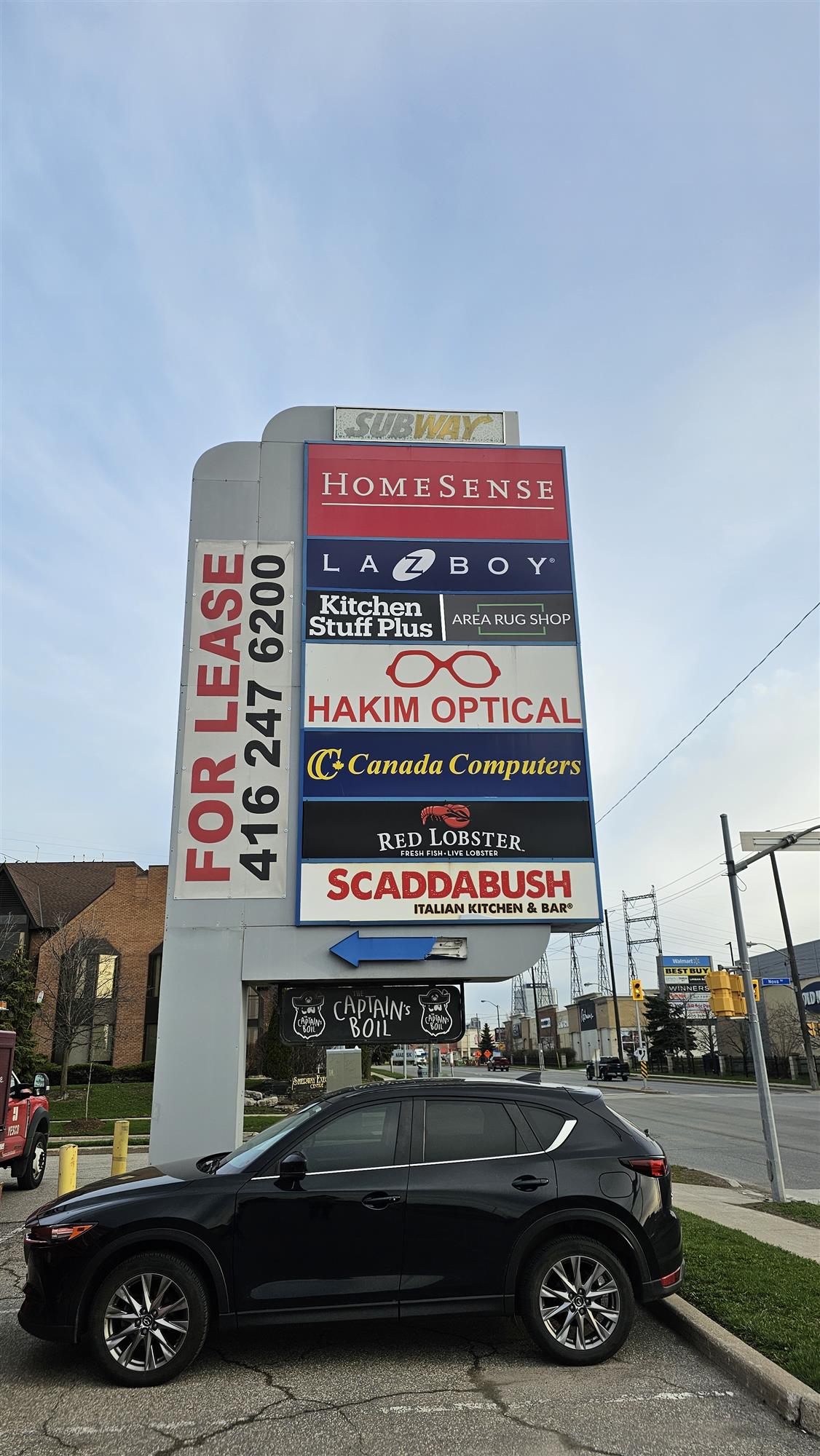 a multi business sign including HomeSense and Subway