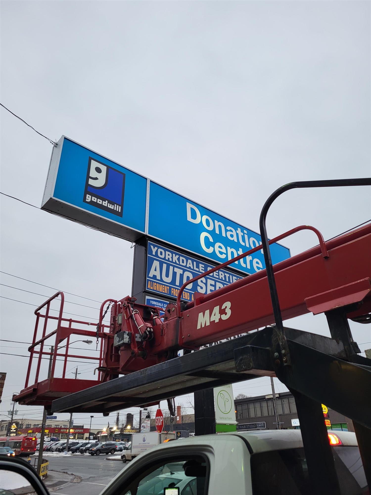 blue and white Goodwill donation centre sign repair with yesco truck