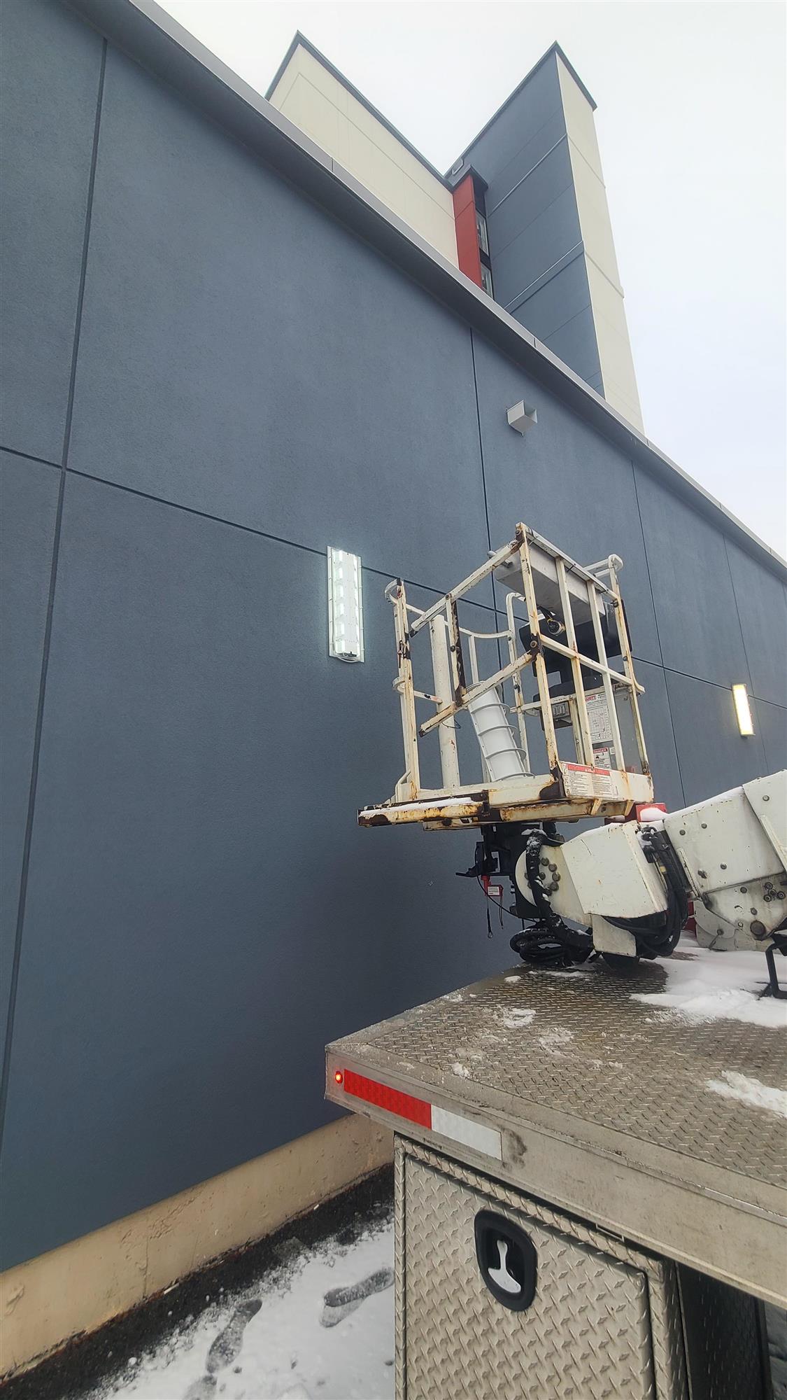 white yesco truck up against the Hilton Garden Inn repairing wall sconce lights