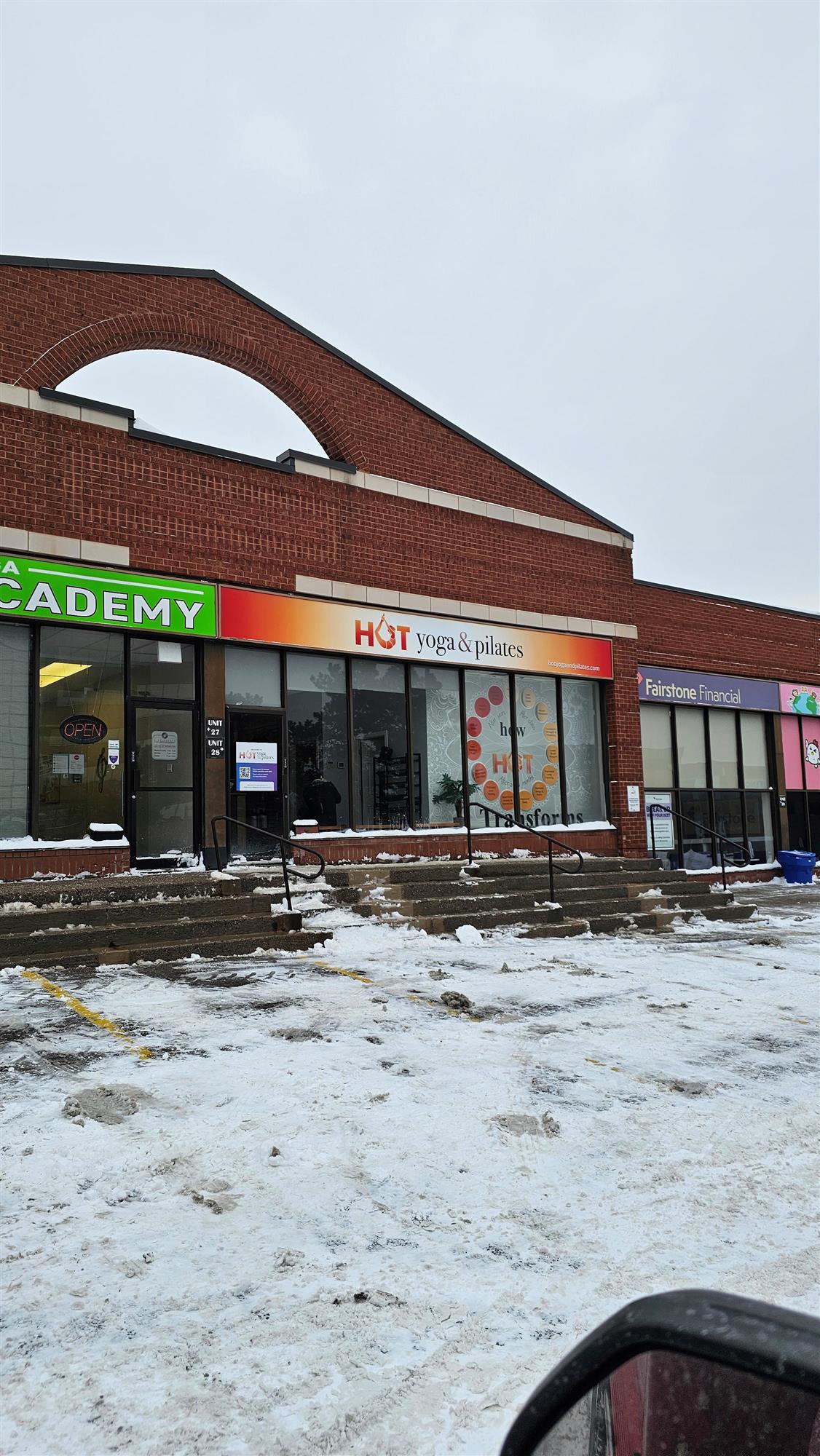 the outside of Hot yoga and Pilates studio with a red and orange sign