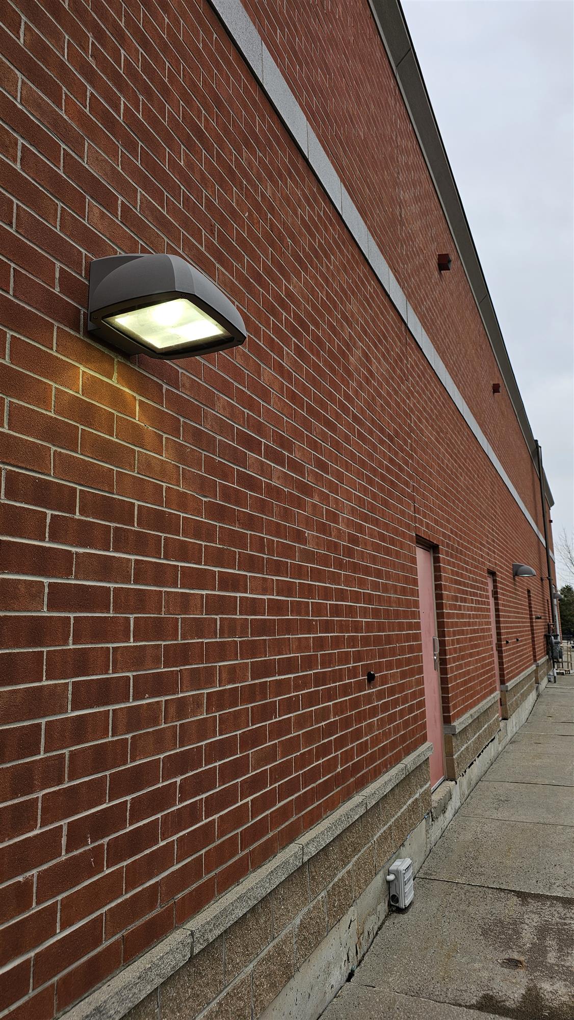 a brick building with bright wall pack light
