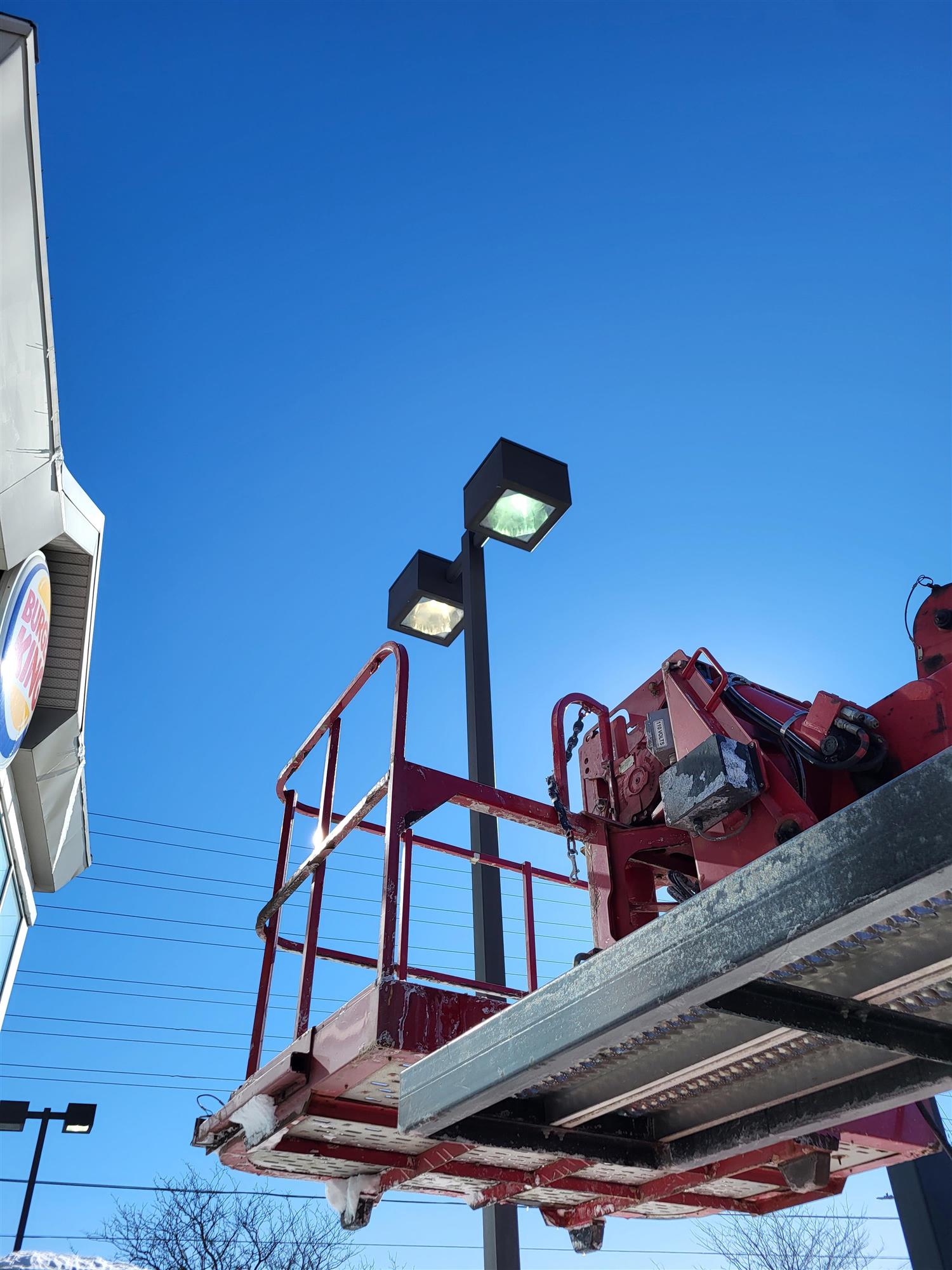 a parking lot pole light at Burger King being repaired