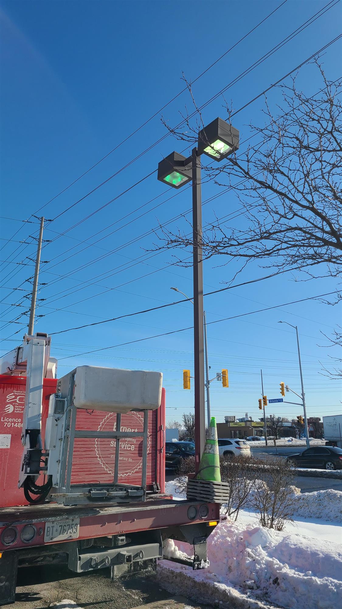 a red Yesco truck in Burger King parking lot repairing pole light
