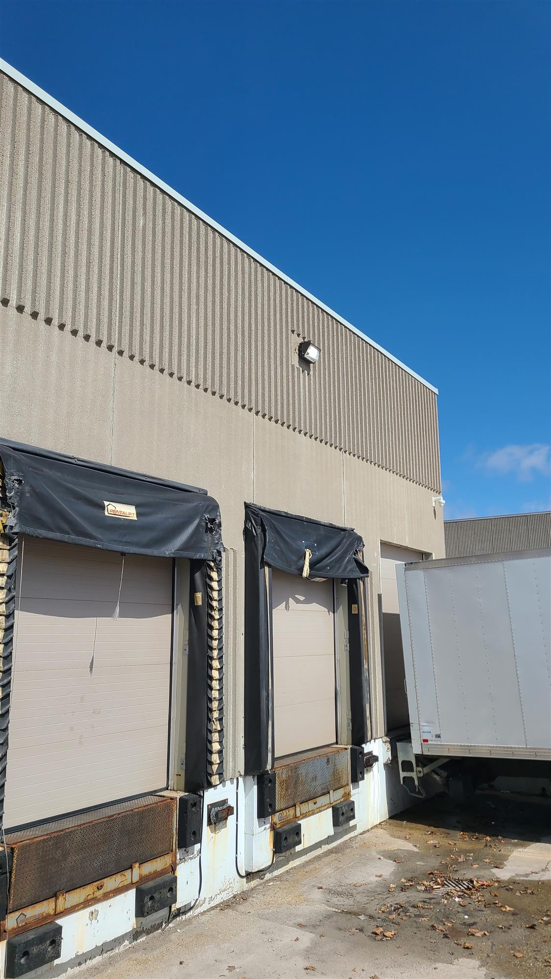 a beige building with 2 loading doors