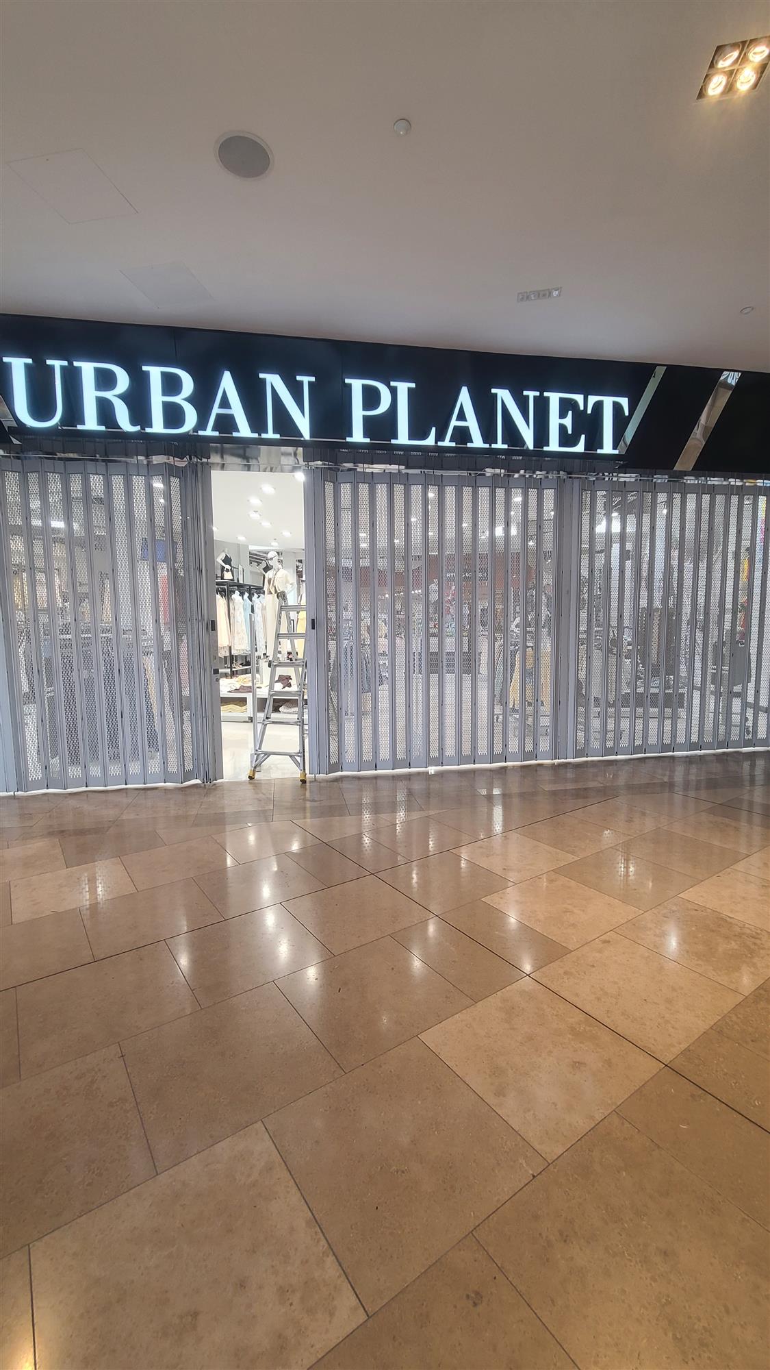 Urban Planet sign in mall with accordion doors closed