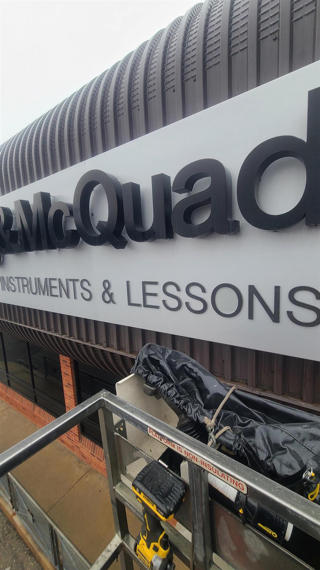 a black and grey Long and McQuade sign over store on building
