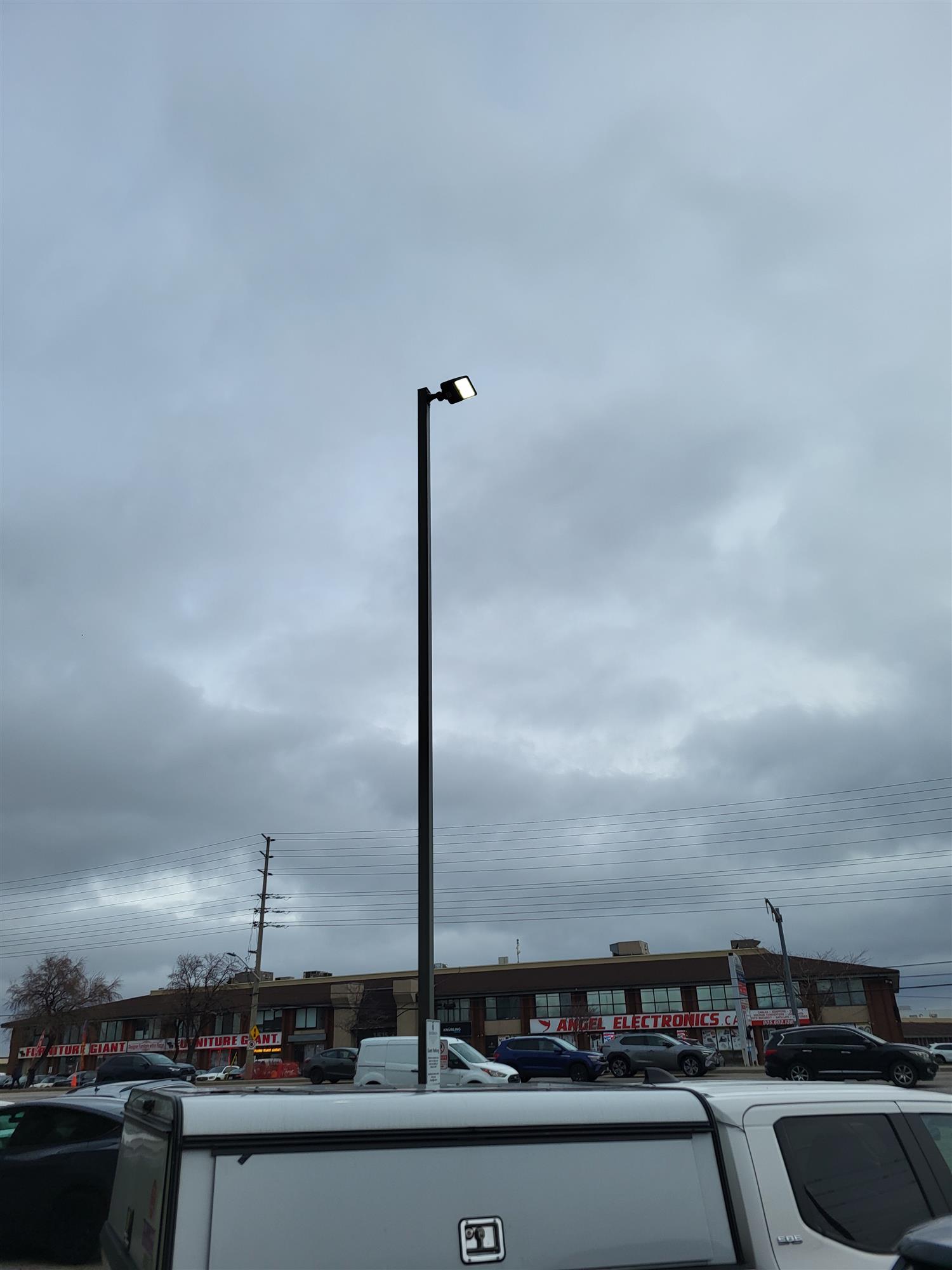 a pole light in a parking lot illuminated