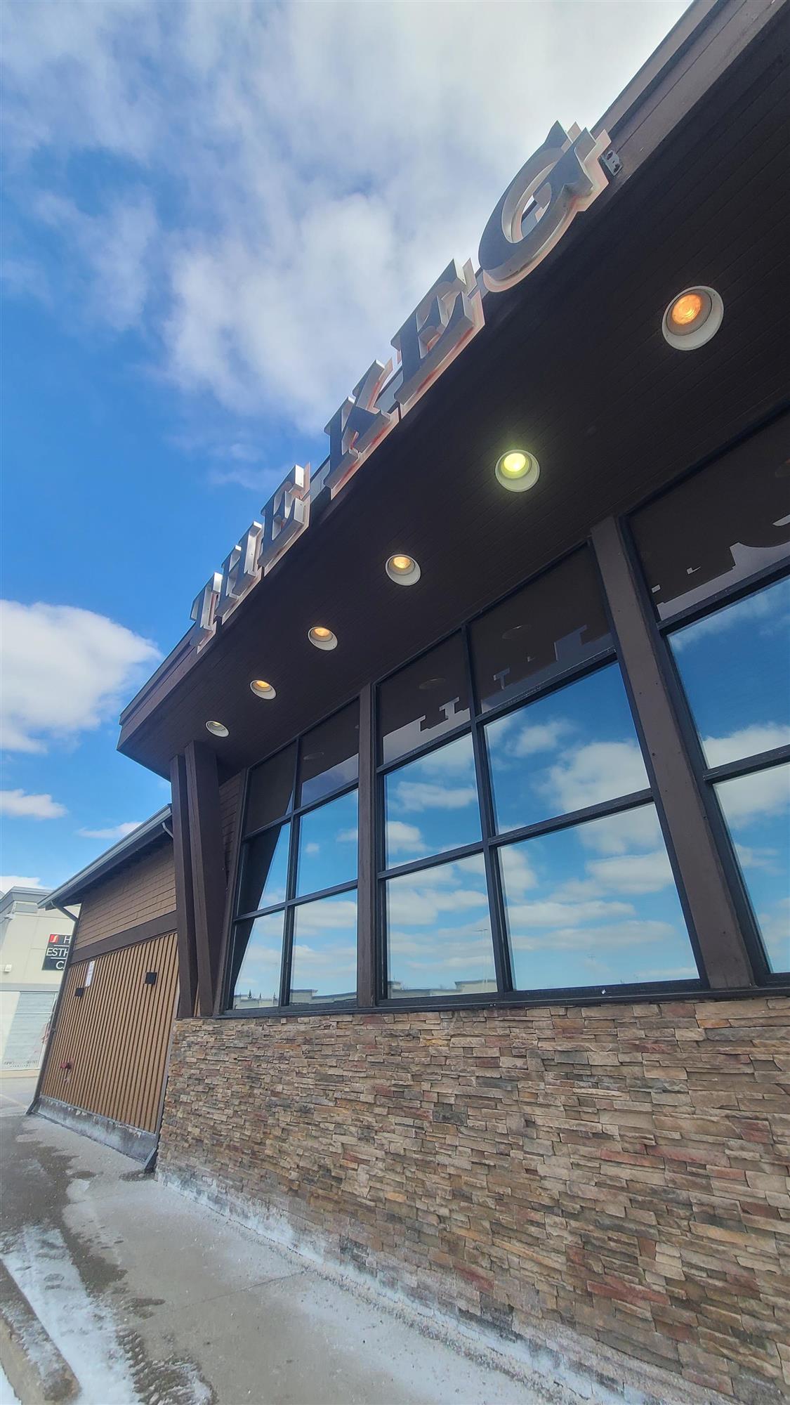 the outside of the Keg restaurant with pot lights illuminated