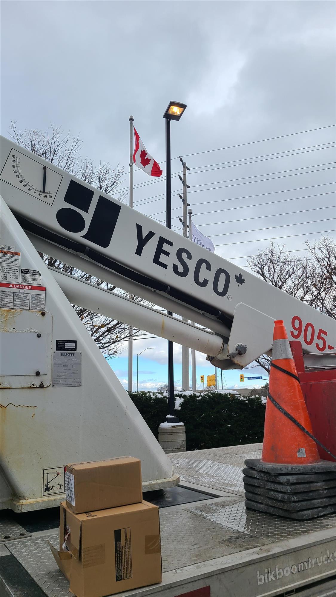 a white Yesco truck beside a Polelight that is being repaired