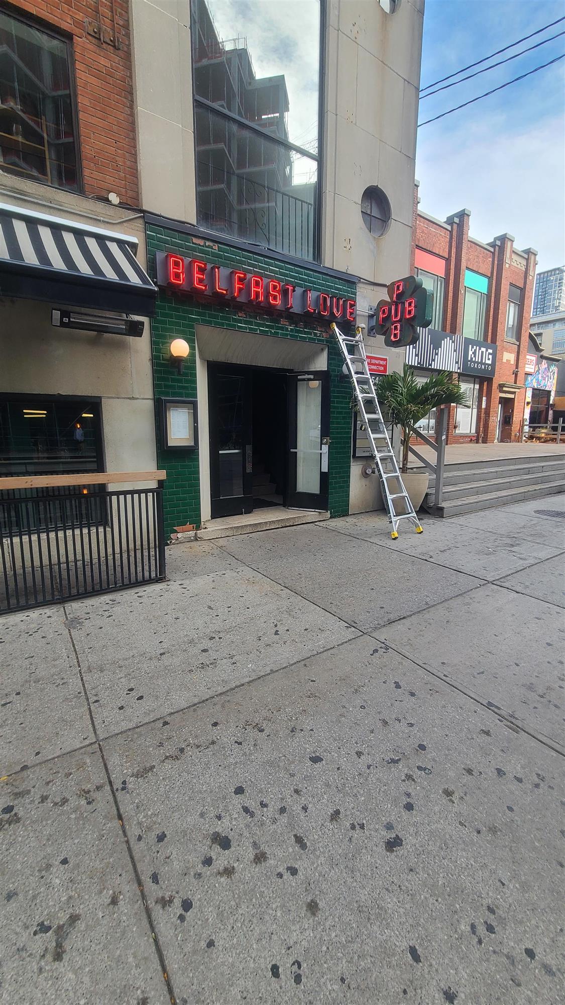 a green building with a red neon sign that says Belfast Love